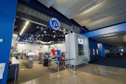 Entrance to the Boeing Tour, featuring merchandise displays and a large window showcasing aircraft models.