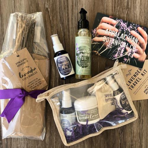 Lavender products including bundles, mist, massage oil, cream, and a travel kit, arranged on a wooden surface.