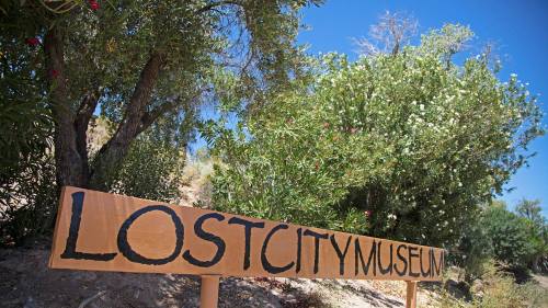 Sign for the Lost City Museum surrounded by greenery and blue sky.