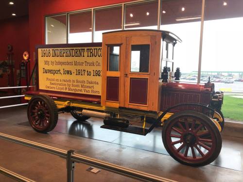 A vintage 1918 Independent Truck displayed in a museum, featuring wooden panels and historical signage.