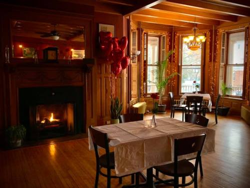 Cozy restaurant interior with a fireplace, heart-shaped balloons, and warm lighting, creating an inviting atmosphere.