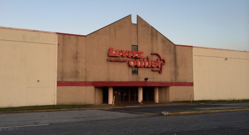 Exterior of a Levitz furniture outlet building, featuring a large sign and a simple, modern architectural design.