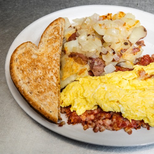 A plate of breakfast featuring scrambled eggs, hash browns with onions, and a slice of toasted bread.