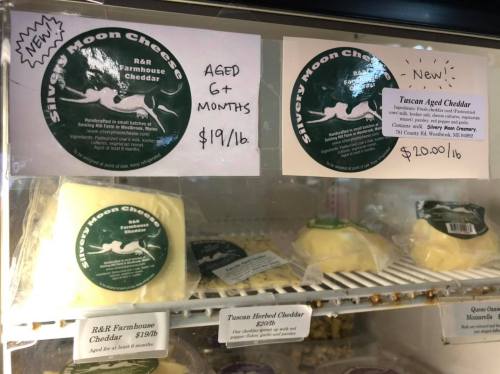 Two cheese labels in a display case: R&R Farmhouse Cheddar ($19/lb) and Tuscan Aged Cheddar ($20/lb).
