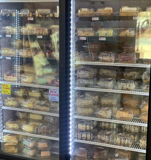A display case filled with various packaged desserts, showcasing multiple flavors and types of treats.