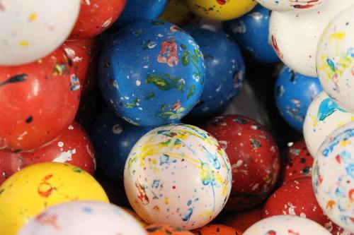 Colorful, speckled balls in red, blue, yellow, and white, clustered together in a playful arrangement.
