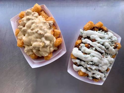 Two trays of tater tots: one topped with creamy gravy and the other with a mix of meat and white sauce.