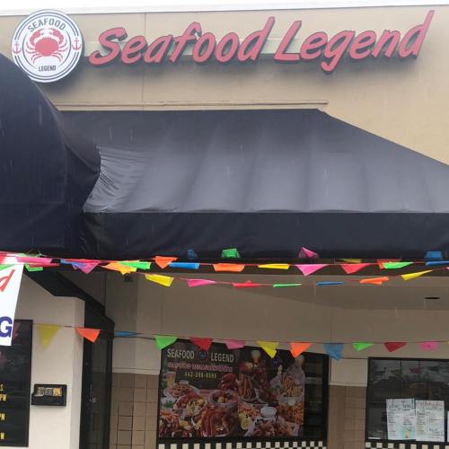 Sign for "Seafood Legend" restaurant with colorful banners and a covered entrance.