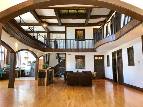 Spacious interior of a modern home featuring wooden beams, a balcony, and large windows with natural light.