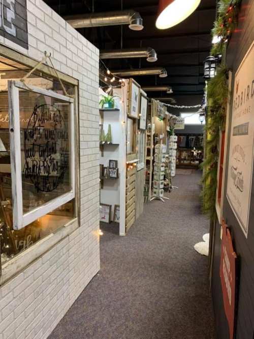A cozy indoor market with decorated walls, shelves of goods, and warm lighting creating a welcoming atmosphere.