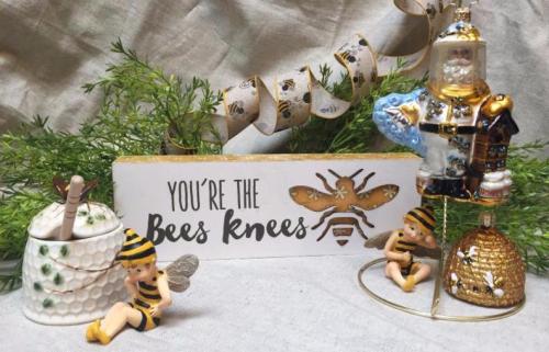 A decorative display featuring a sign that says "You're the Bees Knees," bee-themed ornaments, and figurines.