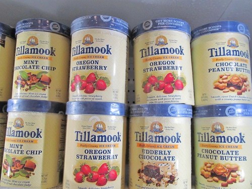 A display of Tillamook ice cream tubs in various flavors, including Oregon Strawberry, Mint Chocolate Chip, and Udderly Chocolate.