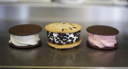 Three ice cream sandwiches: one with chocolate cookies and vanilla, one with a cookie and chocolate chips, and one with pink filling.