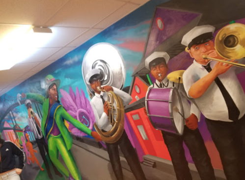 Colorful mural depicting musicians in vibrant costumes playing brass instruments, celebrating a lively atmosphere.