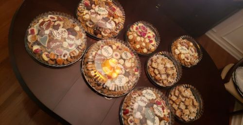 A table filled with assorted dessert trays, each labeled with the word "love."