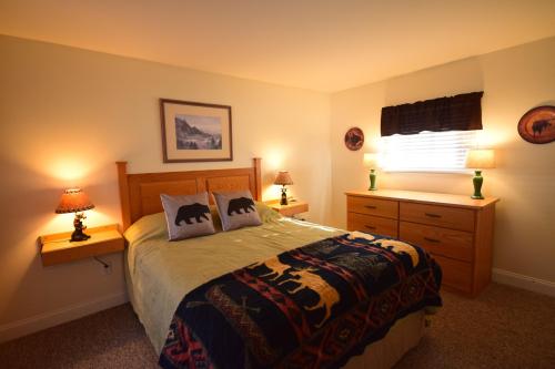 Cozy bedroom with a wooden bed, bear-themed decor, lamps, and a dresser, illuminated by warm lighting.