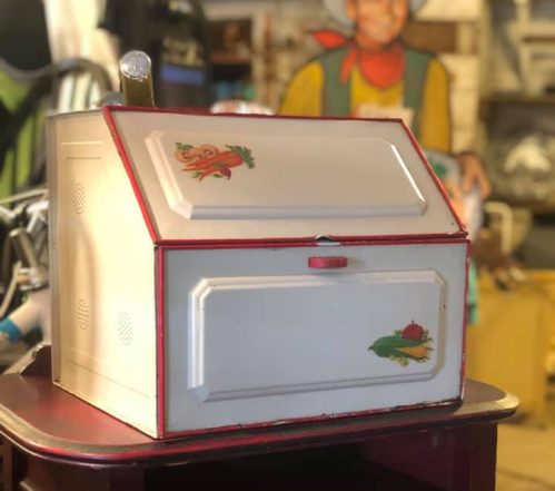 A vintage-style white box with colorful vegetable illustrations, sitting on a table in a rustic setting.