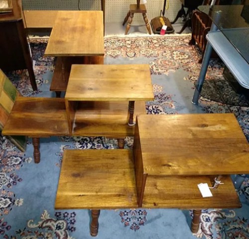 A collection of wooden tables in various sizes arranged on a patterned rug.