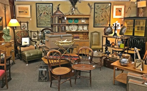 A cozy antique shop filled with various vintage furniture, decor, and artwork, creating an eclectic atmosphere.