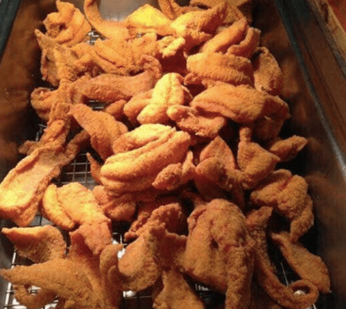 A tray filled with golden-brown, crispy fried chicken pieces.
