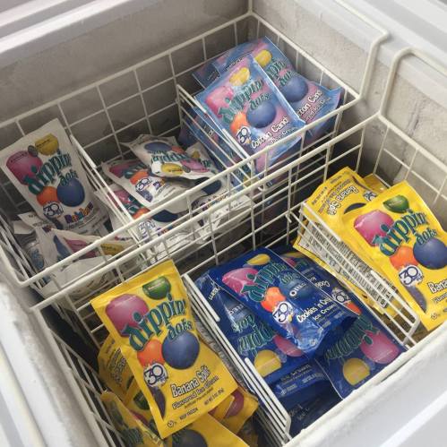 A freezer filled with colorful packages of Dippin' Dots ice cream in various flavors.