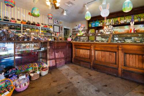 A charming candy shop decorated for Easter, featuring colorful treats, baskets, and festive decorations.