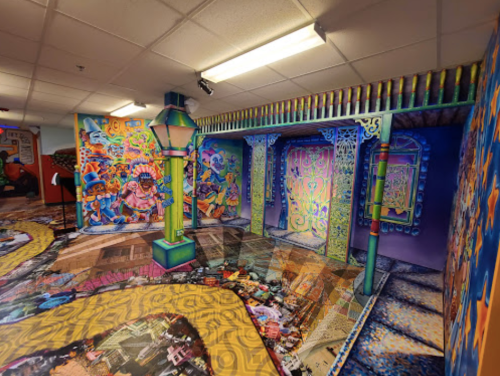 Colorful, vibrant mural-filled room with artistic walls and a patterned floor, creating a lively, immersive atmosphere.