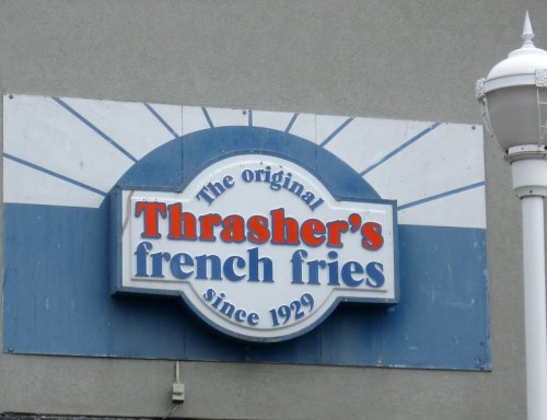 Sign for Thrasher's French Fries, established in 1929, featuring blue and white design.