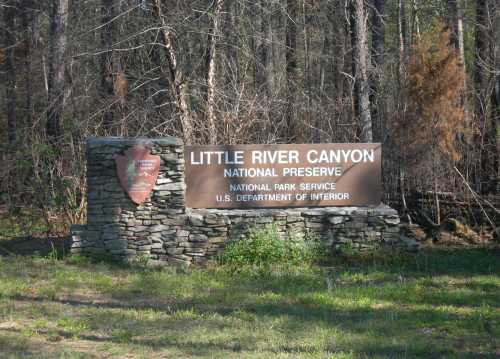 Sign for Little River Canyon National Preserve, surrounded by trees, indicating it's part of the National Park Service.