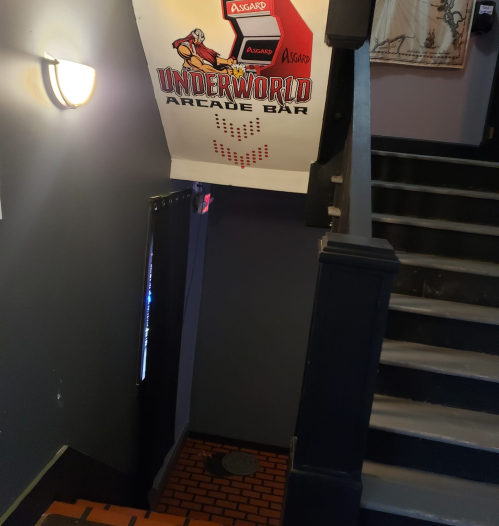 Staircase leading to the Underworld Arcade Bar, featuring an Asgard-themed sign above.