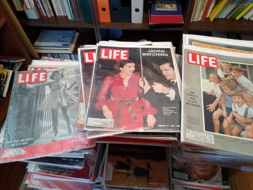 A stack of vintage LIFE magazines featuring various covers, including one with Jackie Kennedy.
