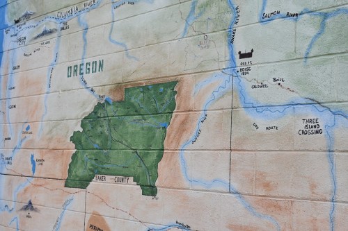 Map mural of Oregon highlighting Baker County, with rivers and landmarks illustrated in vibrant colors.
