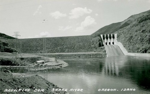 Black and white photo of Brownlee Dam on the Snake River, Oregon-Idaho, with water flowing from the dam.