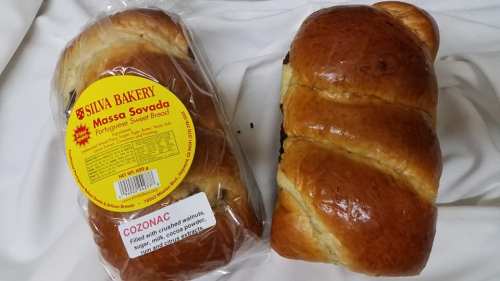 Two loaves of Portuguese sweet bread, one in packaging labeled "Massa Savada" and the other unwrapped.