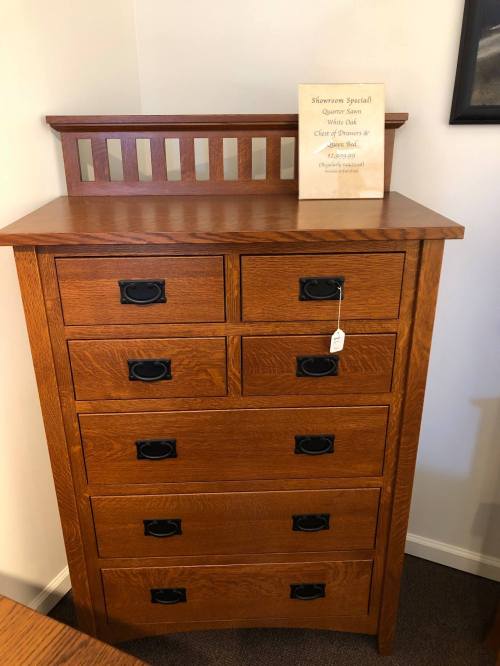 A wooden dresser with six drawers and a decorative top, featuring a sign that reads "Sherman Special."