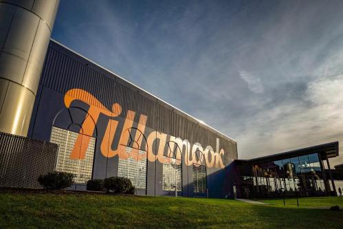 Exterior of the Tillamook building, featuring large orange lettering against a blue wall and a grassy area in front.