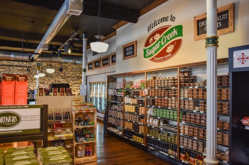 Interior of Sugar Creek Country Store, featuring shelves of snacks, candies, and a welcoming sign.
