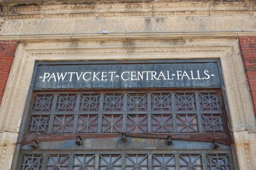 Sign above a large, ornate door reading "Pawtucket Central Falls" with decorative architectural details.