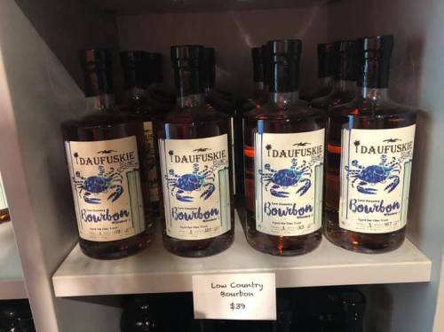 Bottles of Daufuskie Bourbon displayed on a shelf with a price tag reading "Low Country Bourbon $39."