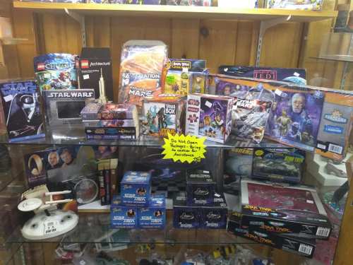 Display case filled with various sci-fi toys and collectibles, including Star Wars and Star Trek items.