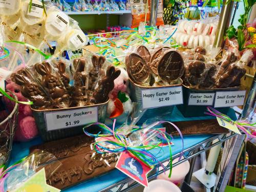 Display of colorful Easter-themed chocolate suckers and bunnies, with prices labeled on each item.