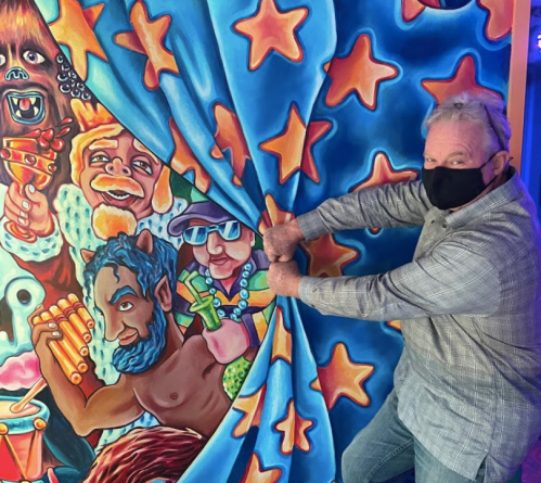 A person in a mask pulls back a colorful curtain revealing vibrant, cartoonish characters and stars.