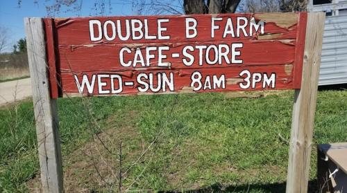 Sign for Double B Farm Cafe-Store, open Wednesday to Sunday from 8 AM to 3 PM, with a rustic wooden design.