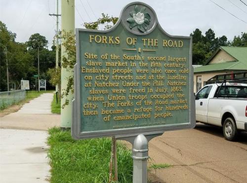 Historical marker titled "Forks of the Road," detailing the site of a former slave market in Natchez, Mississippi.