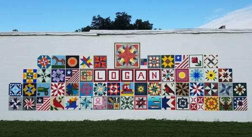 Colorful mural featuring various quilt patterns and the name "LOGAN" prominently displayed in the center.
