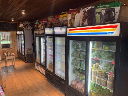 A grocery store interior featuring multiple glass-front refrigerators filled with various food items and bags on shelves above.