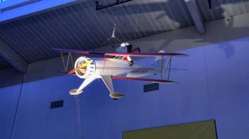 A model biplane hangs from the ceiling, featuring Snoopy as a pilot in a red scarf.