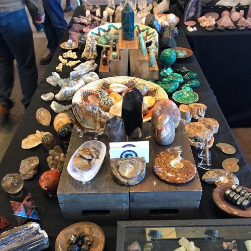 A display of various gemstones and crystals arranged on a table, showcasing their colors and shapes.