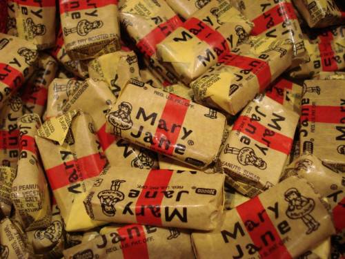 A pile of individually wrapped Mary Jane peanut butter candies with vintage-style packaging.