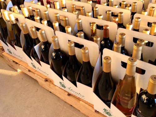 A display of various wine bottles arranged in cardboard holders on a wooden pallet.